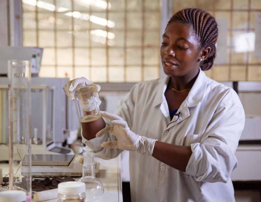 Chemist examining a beaker at a crude oil processing lab in Arusha, Tanzania