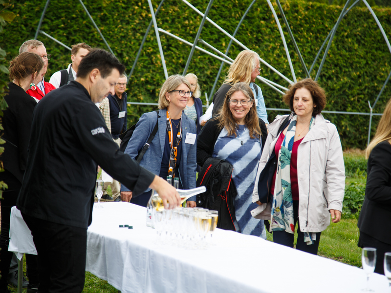 Deltagare på invigningen av SLU Grogrund serveras dricka. Foto.