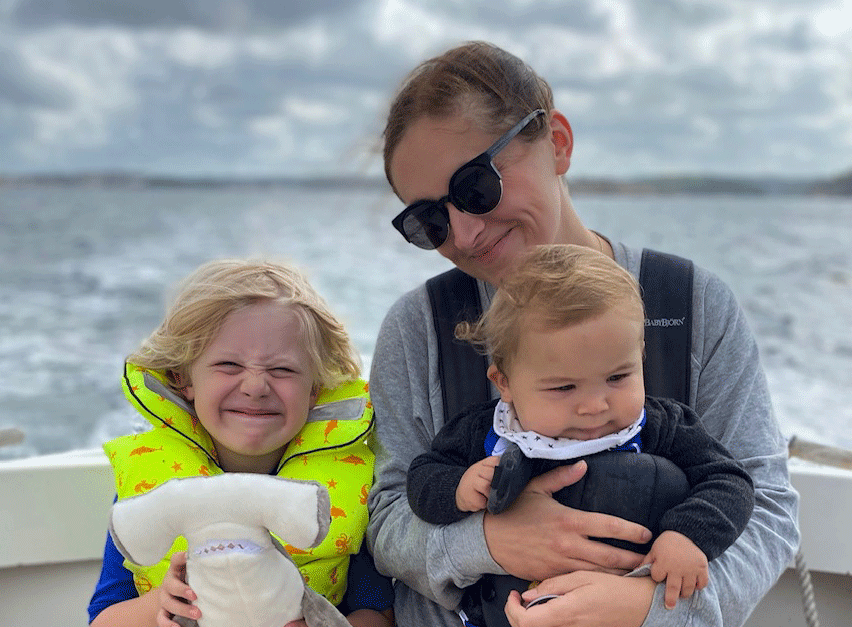 en mamma med sina två barn på en båt