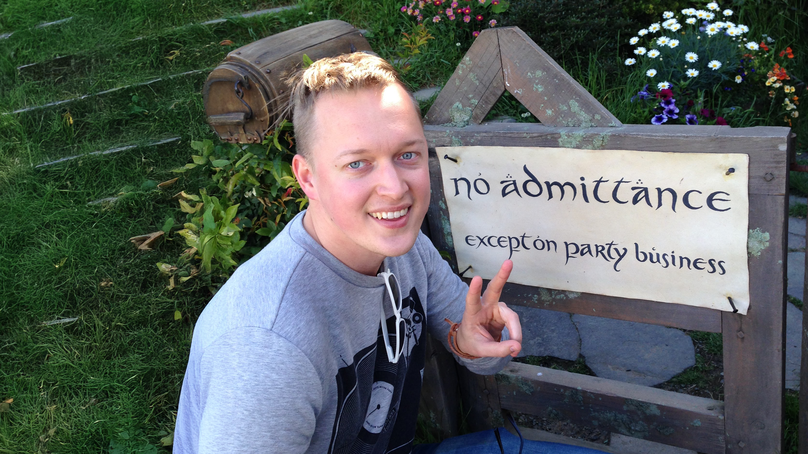 Henrik poserar framför en skylt som säger "No admittance except on party business".