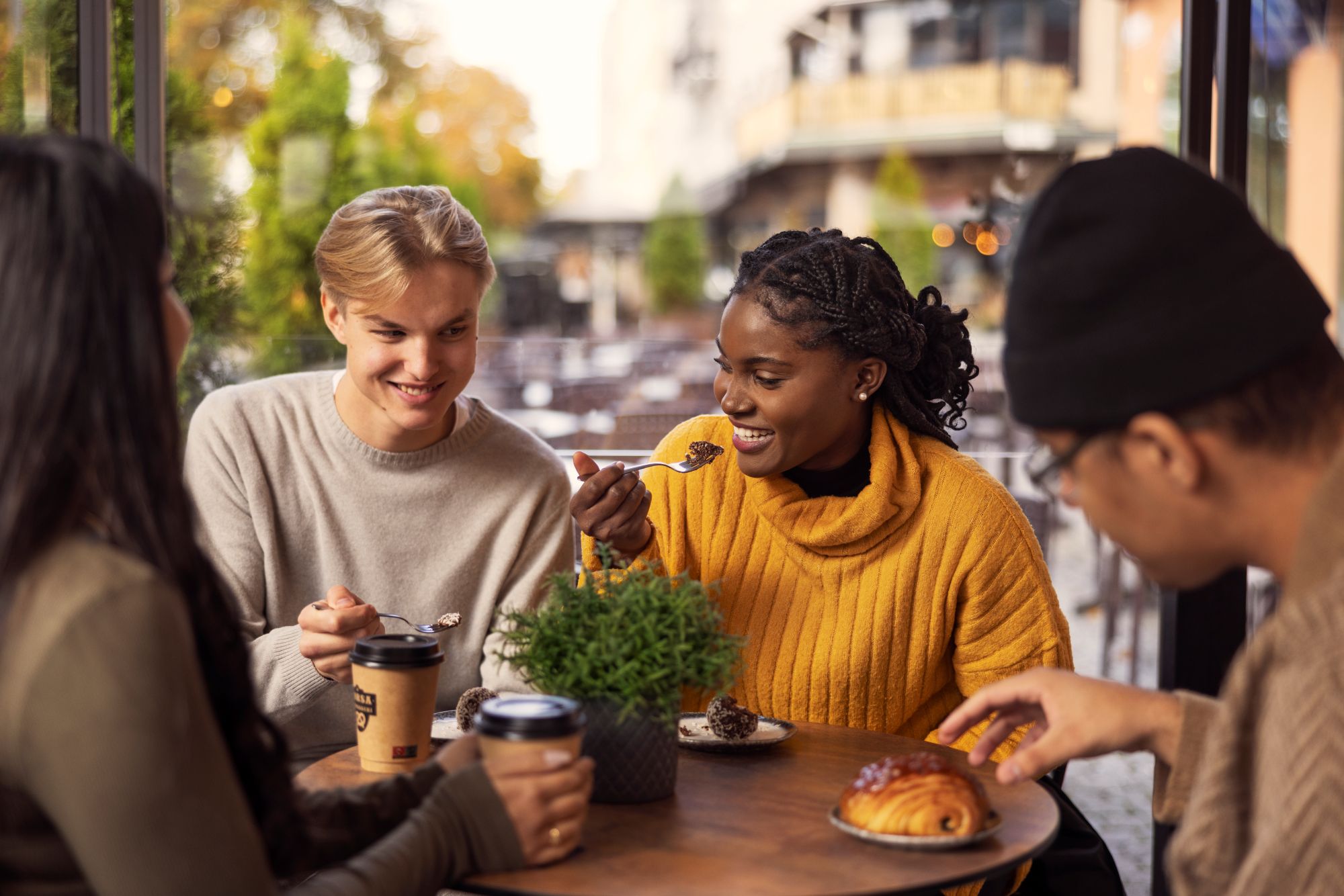 three young people are sitting in a café