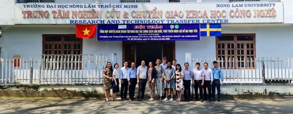 A group of people posing in front of building in Vietnam