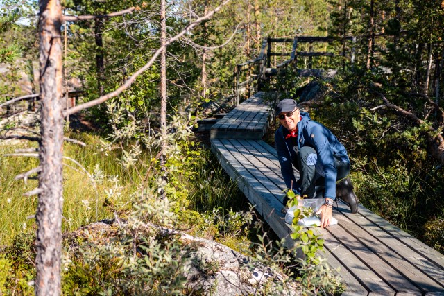 Thomas Beery på en spång som går över en våtmark i en tallskog