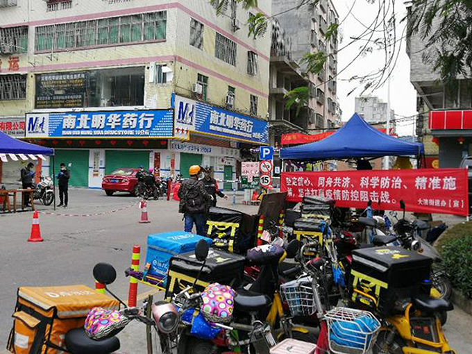 In the time of the COVID-19 shutdown an entrance to the urban village with the deliverymen`s bicycles in the foreground in 7th February Shenzhen. The commercial street of the village was completely closed.