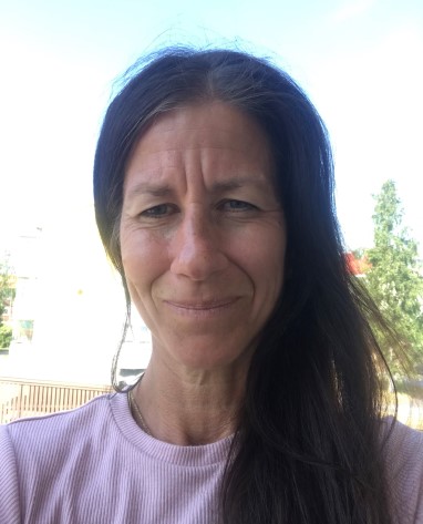 woman with dark long hair and pink sweater