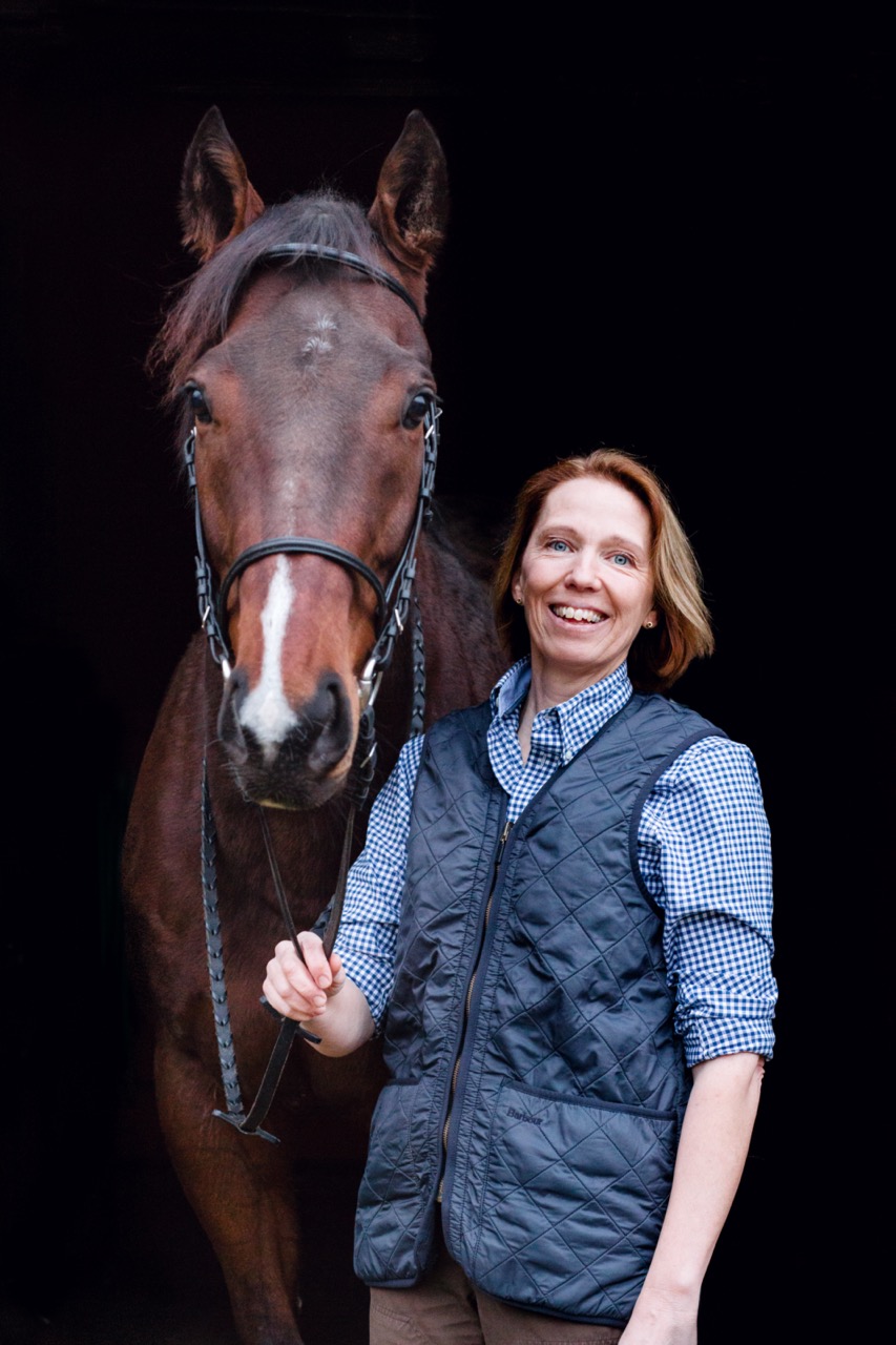 Bild på Sara Nyman tillsammans med en brun häst.