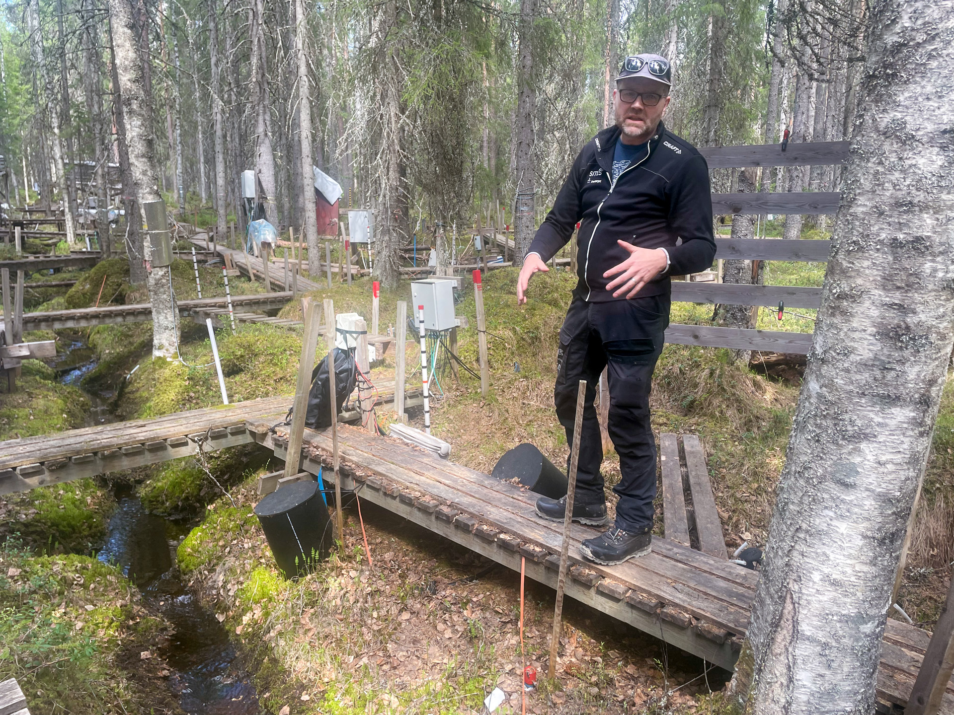 Hjalmar in a forest with trails and equipment used for research experiments.