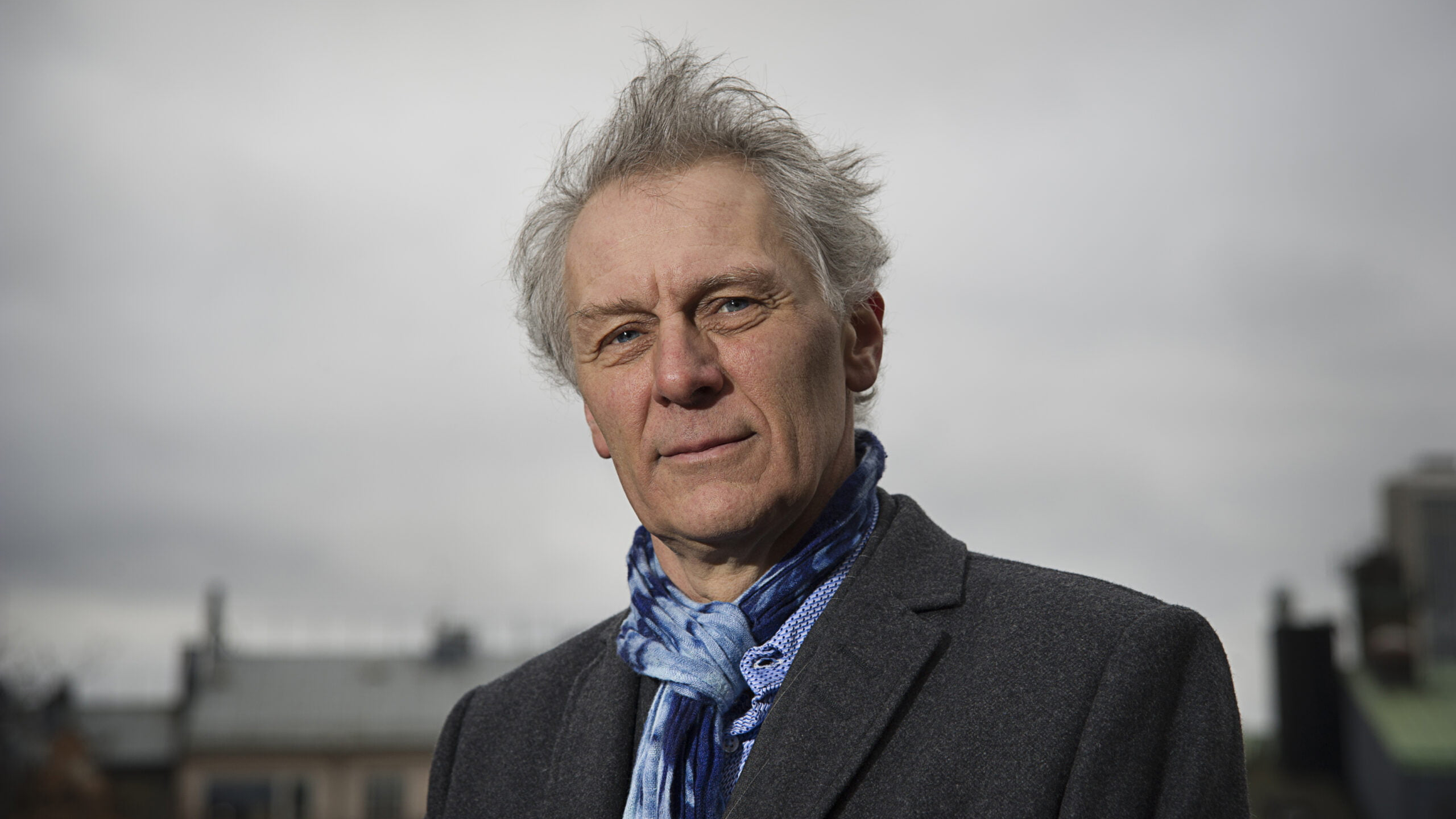 A man with grey hair and a blue shirt.