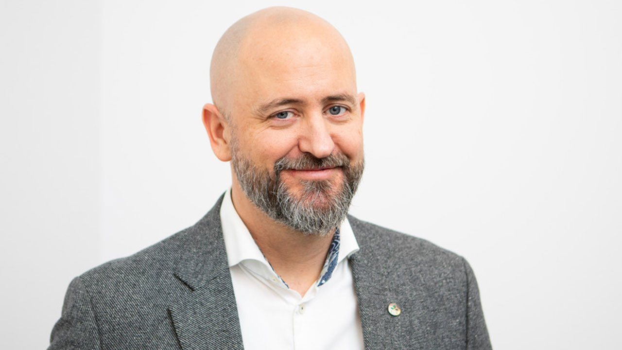 Headshot of a man with a beard and jacket.